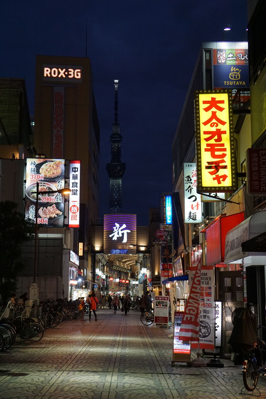 illuminated city street with neon and streetlights — Hiking the ridge: trail map offline, emergency numbers saved.