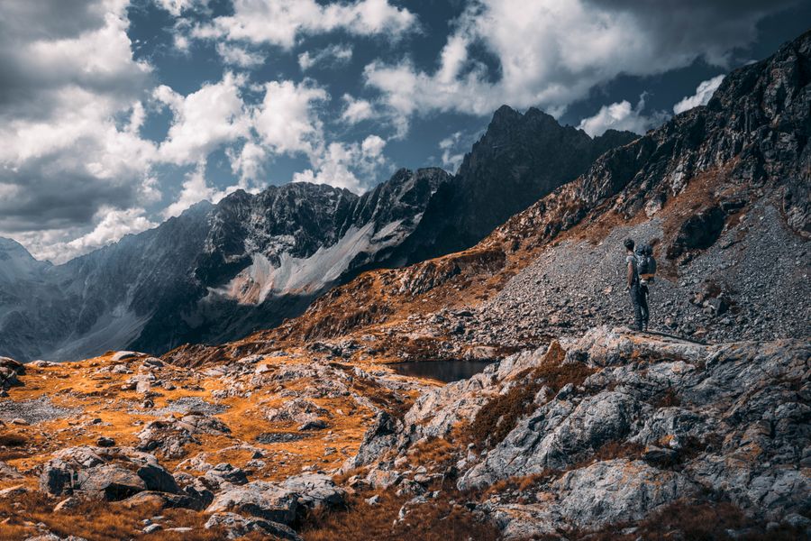 hiker standing on rocky mountain — 195の目的地のどれでも質問可能 — エージェントは各地のネットワークを把握しています。