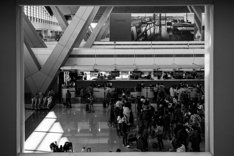 people at airport — Coworking abroad: laptop tethered, calls crisp, deadlines met.
