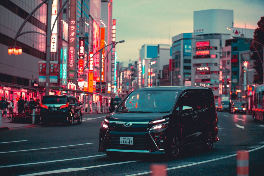 black toyota noah driving down the street in tokyo — Japanのビジネス街：テザリングが会議全体を支えます。