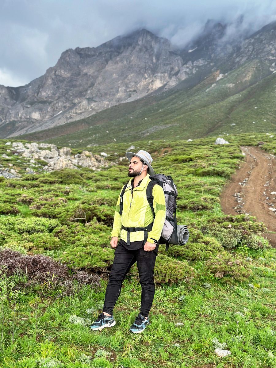 man wearing yellow jacket in a mountain valley — 旅が終わればワンタップで削除 — 契約の残り香なし。