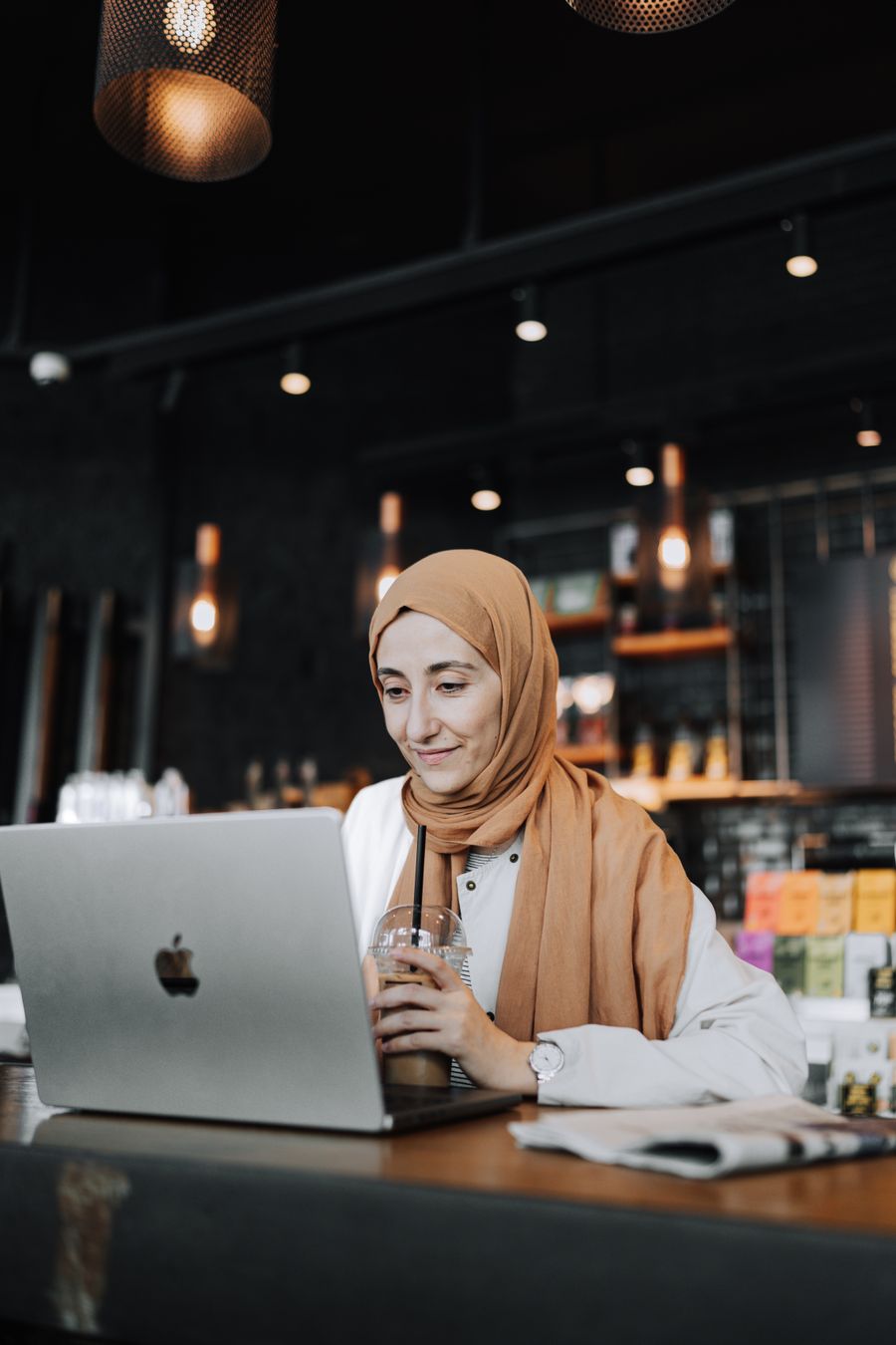 woman using laptop at cafe — バックアップとしてQRを自分宛にメール — 旅の途中での機種変更は起こります。