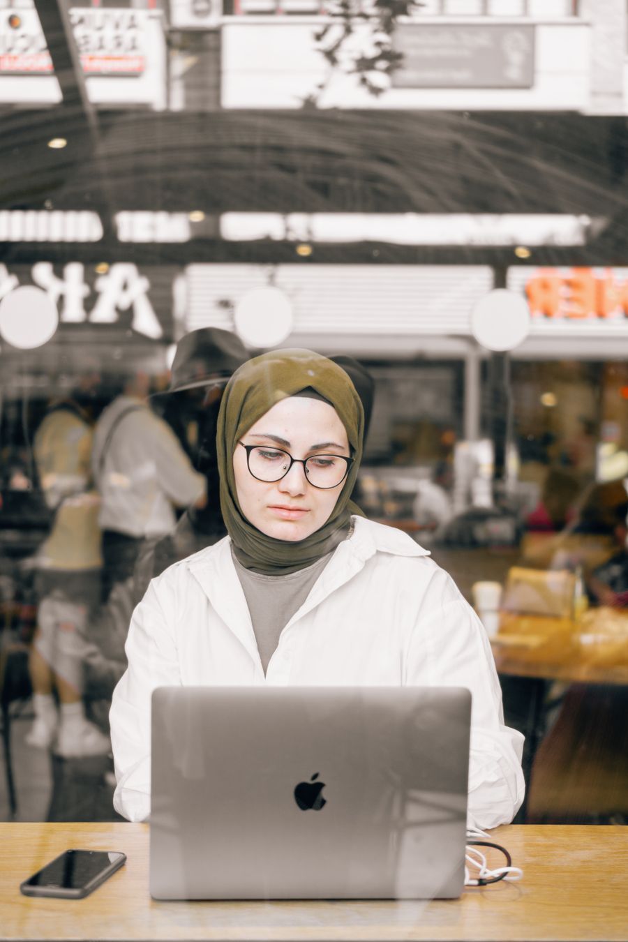 woman using a laptop in a restaurant — What’s My IP?: answers first, never a signup wall.