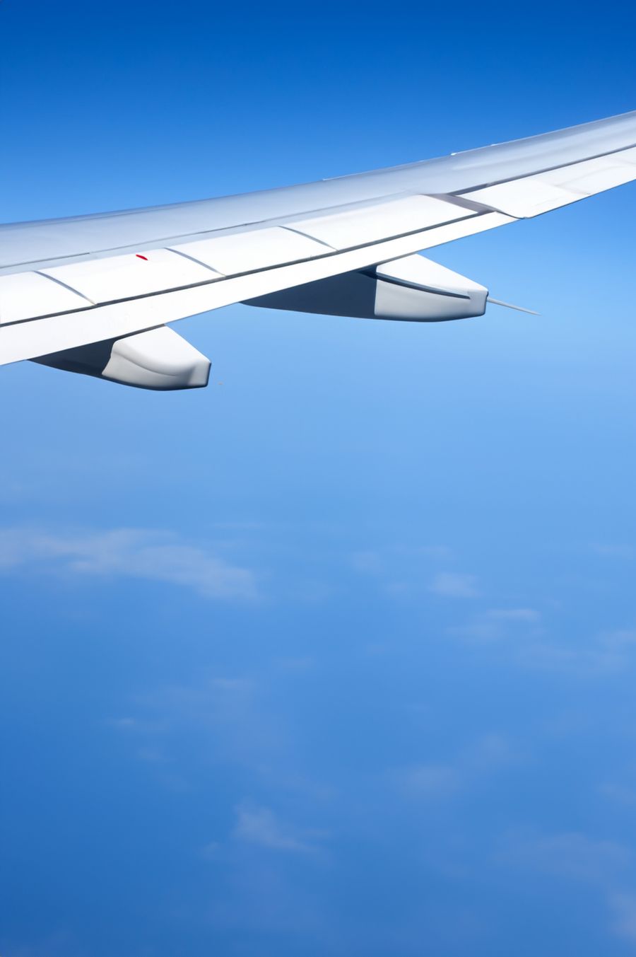 an airplane wing seen from the airplane window — 長い乗継：ストリーミングも仕事もメッセージも、すべて対応。