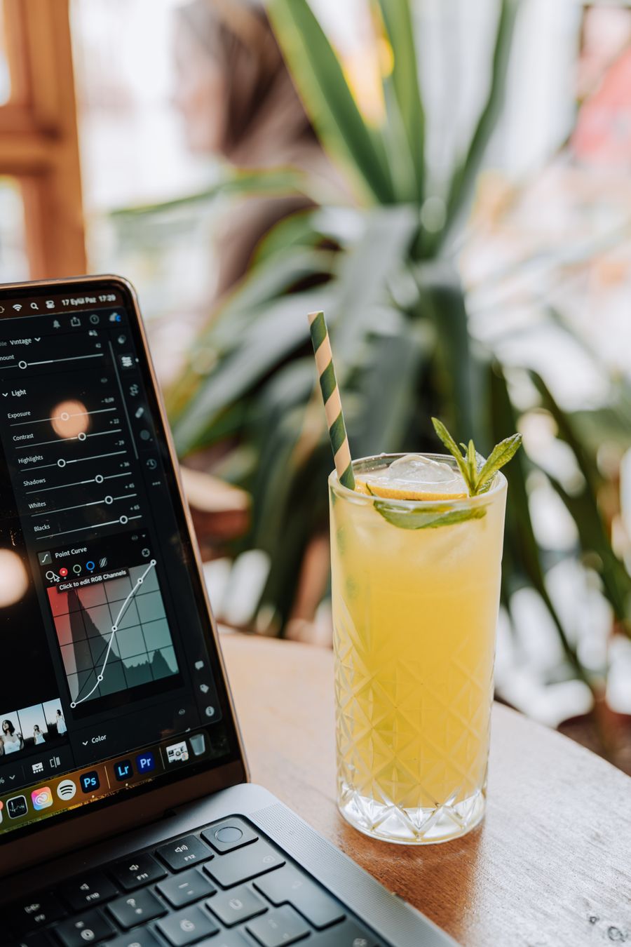 glass with a drink and a straw by a laptop — The modern arrival: online before the seatbelt sign goes off.