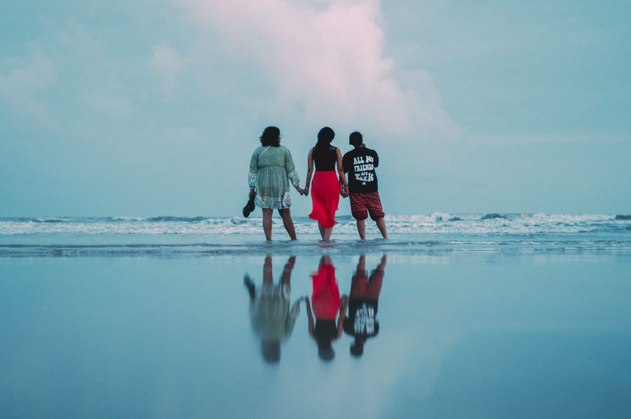 three people walking on the beach with the ocean in the background — Docs: ストリートレベル：ナビ、配車、レビュー、すべて即時に。