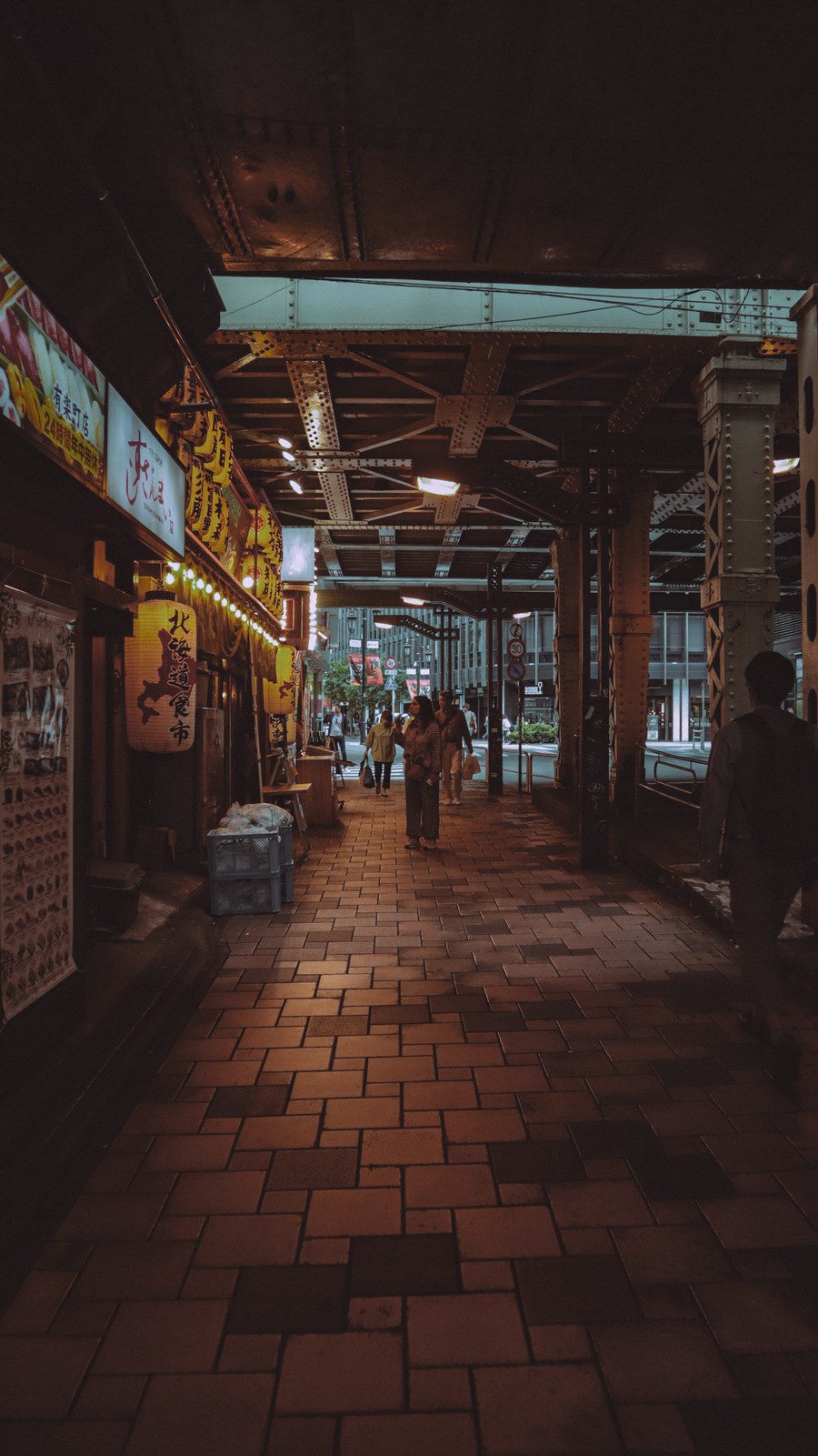 atmospheric tokyo street under railway bridge — The connected trip: maps, messages and translation, all on one eSIM.