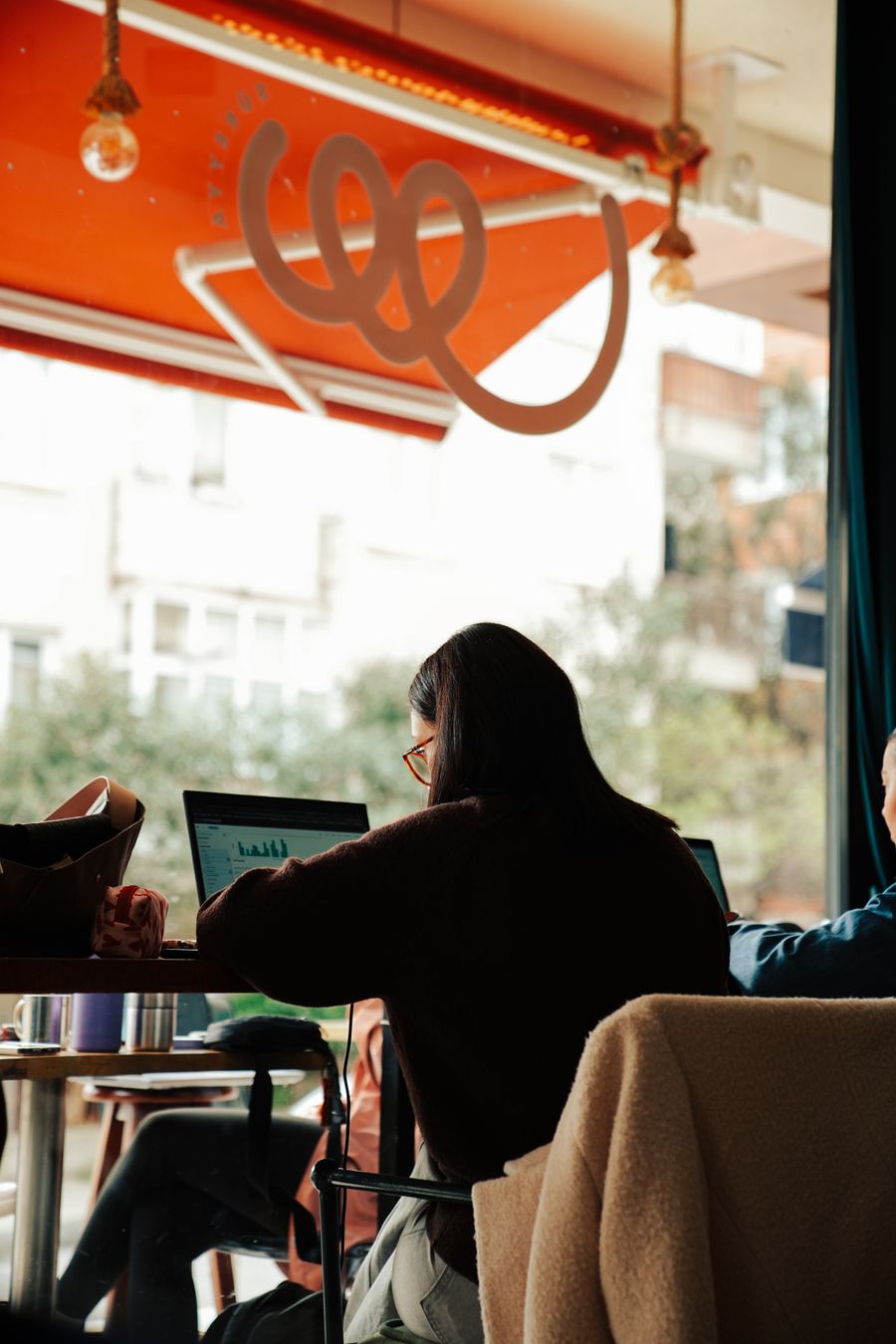 people working on laptops in a cozy cafe — 2分、3ステップ：プランを選んで、スキャンして、オンラインで到着。