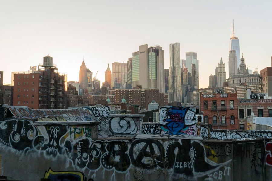 graffiti laden rooftop overlooking new york skyline — The commute, handled: podcasts downloaded, messages sent, no dead zones.
