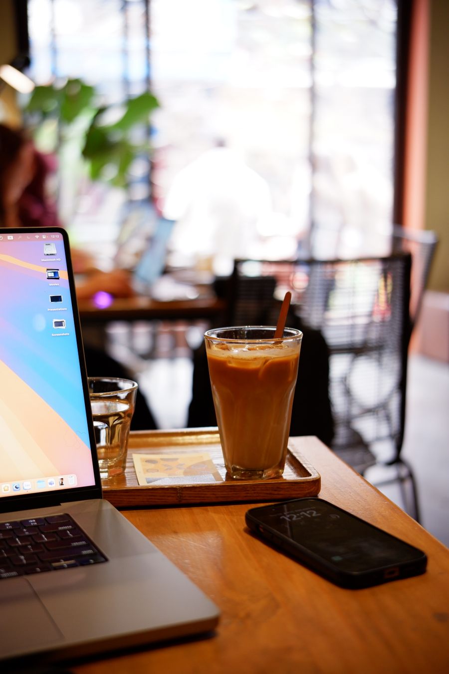 iced coffee on wooden table in modern cafe — The connected trip: maps, messages and translation, all on one eSIM.