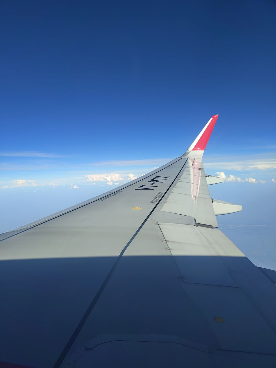 airplane wing view against clear blue sky — Family group chat: location shared, dinner plans settled in minutes.