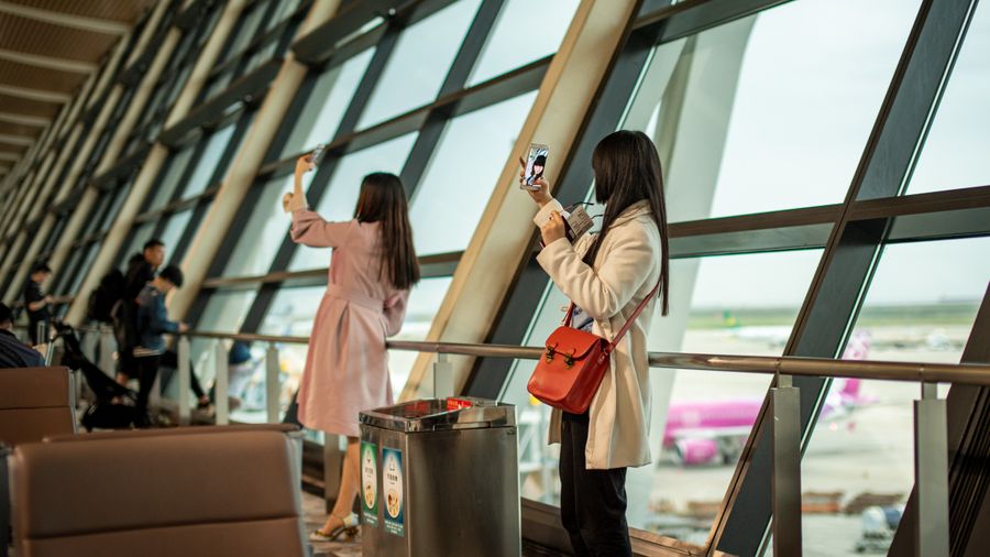 young travelers taking photos at shanghai airport — Resend eSIM QR Code works for anonymous visitors — answers first, signup never forced.