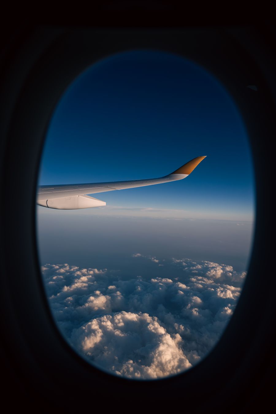 view from airplane window with cloudscape — Downtown, connected: the eSIM finds the fastest local network on its own.
