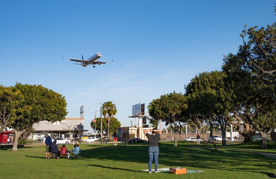 airplane landing over park visitors — Harbor views with full bars: coverage where travelers actually go.