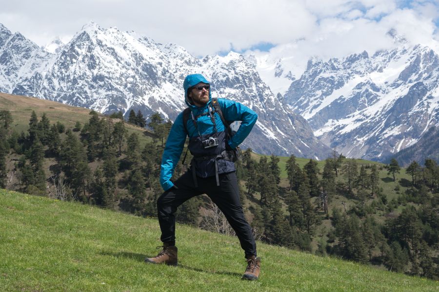 man standing on a grass with snow covered mountains background — The FAQ below Country Connectivity Fact Sheet answers the six questions everyone asks first.
