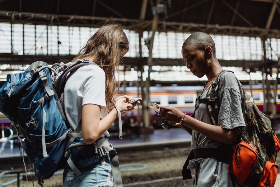 Two adventurous backpackers using smartphones while waiting at a bustling train station. — The spec grid shows exactly what What’s My IP? accepts and what it returns.