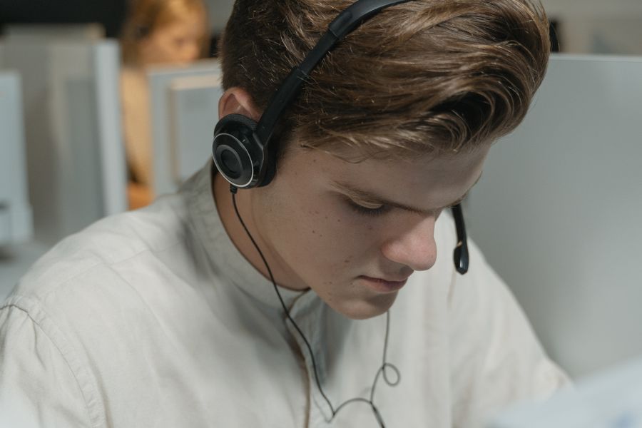 a man in white crew neck shirt wearing black headphones — Platform to platform: tickets, timetables and taxis in one hand.