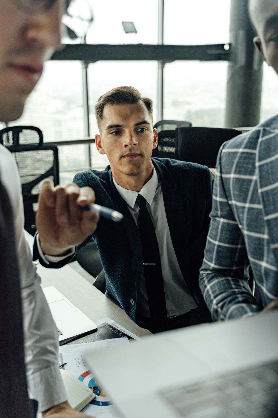 man in black suit pointing a pen