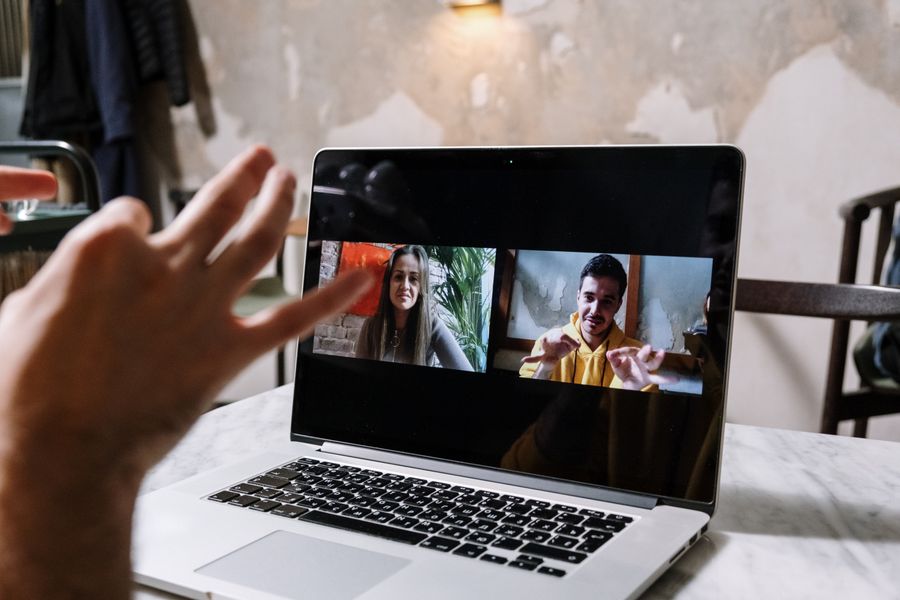 man and woman video call on laptop — The business trip: client deck synced, video call joined from the taxi.