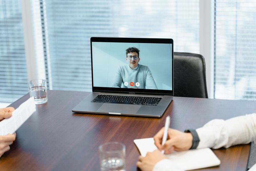 a businessman in an online meeting — The conference badge: QR ticket scanned, session schedule synced.