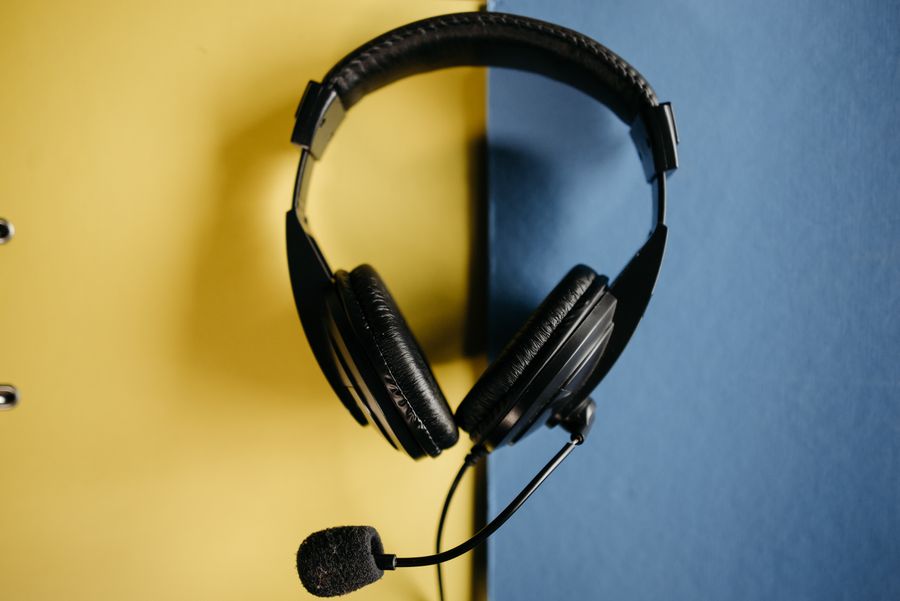 black corded headphones on blue and yellow surface — Rooftop check-in: boarding passes and hotel keys, all on the phone.