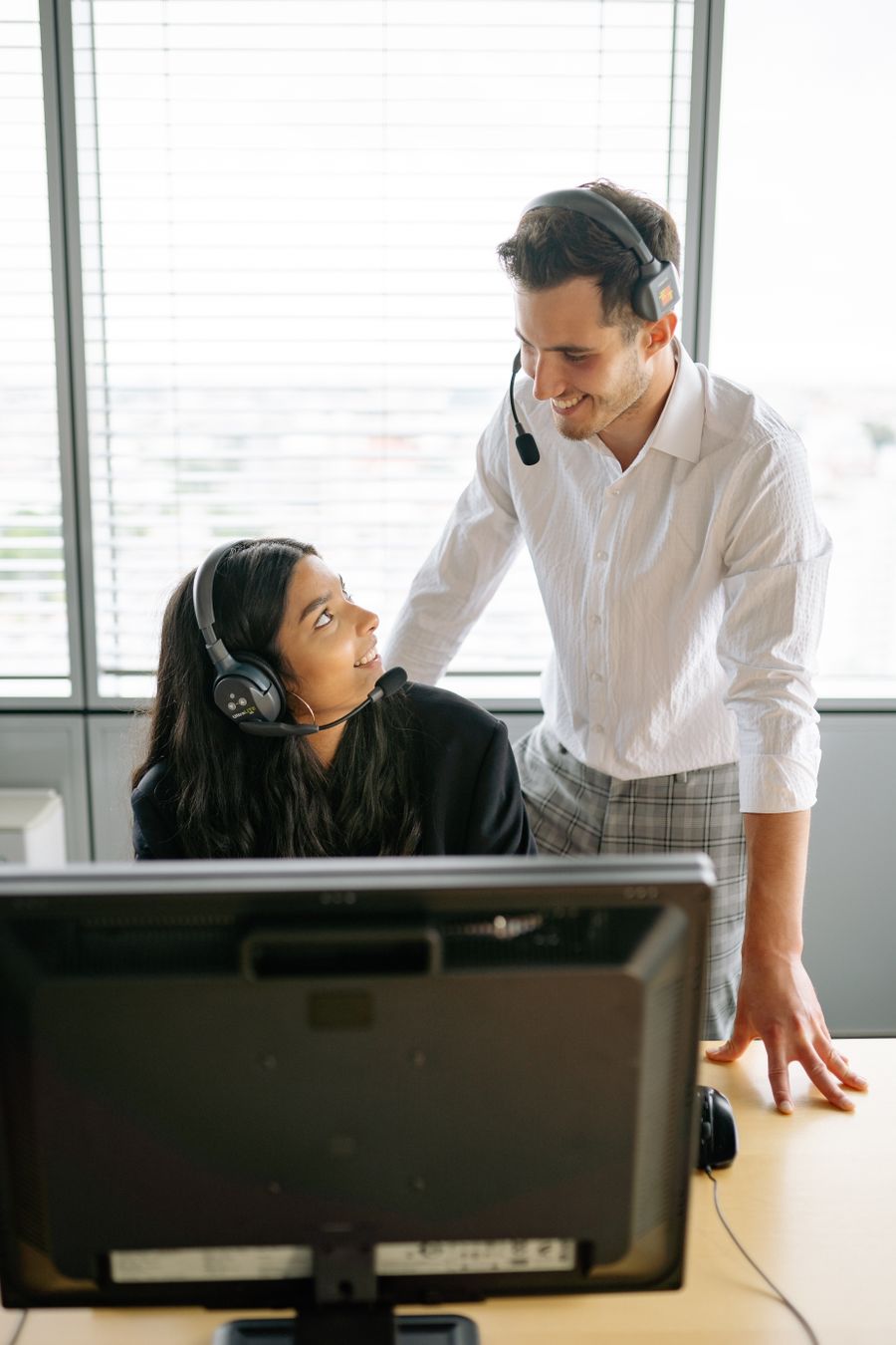 man and woman wearing black headset smiling at each other